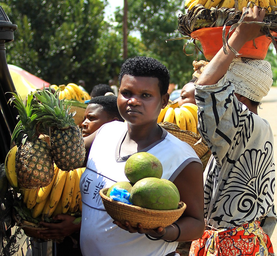 Women selling pineapples and bananas at a roadside in Uganda