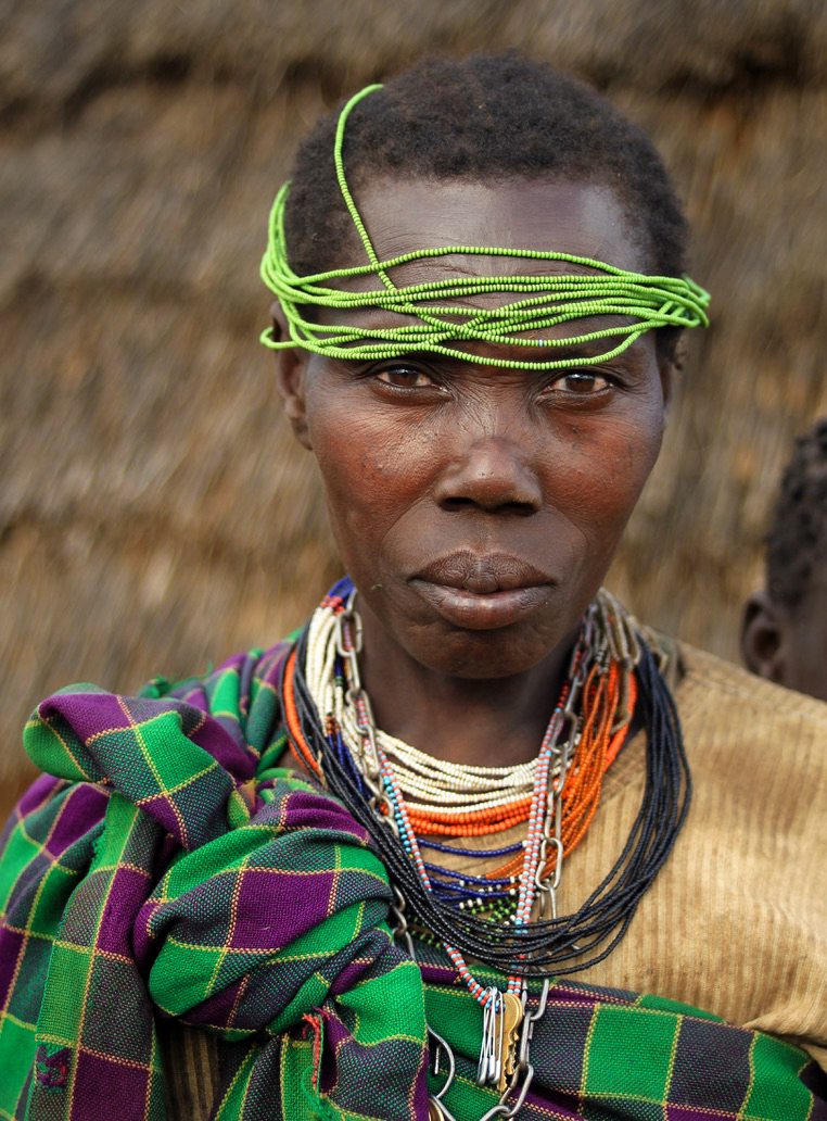 Lurukul woman with green beaded headband and necklaces