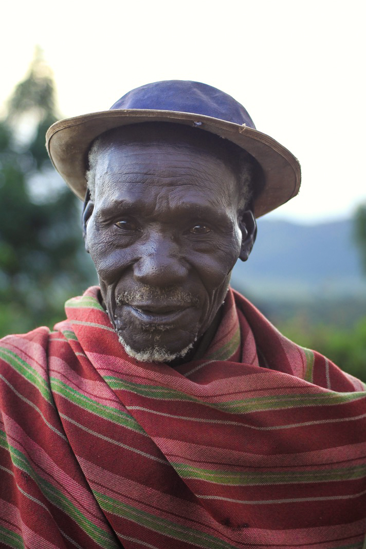 Lurukul elder in a striped blanket and hat