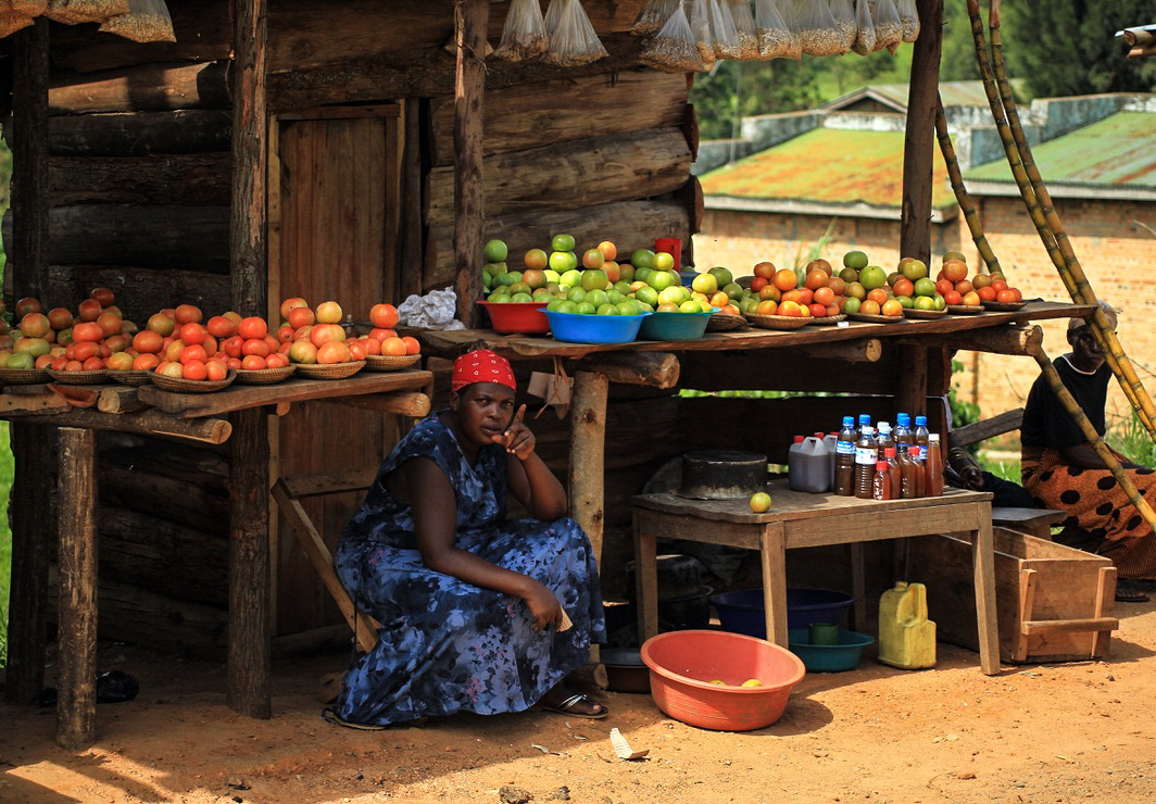 Woman at a fruit and honey stall in Uganda