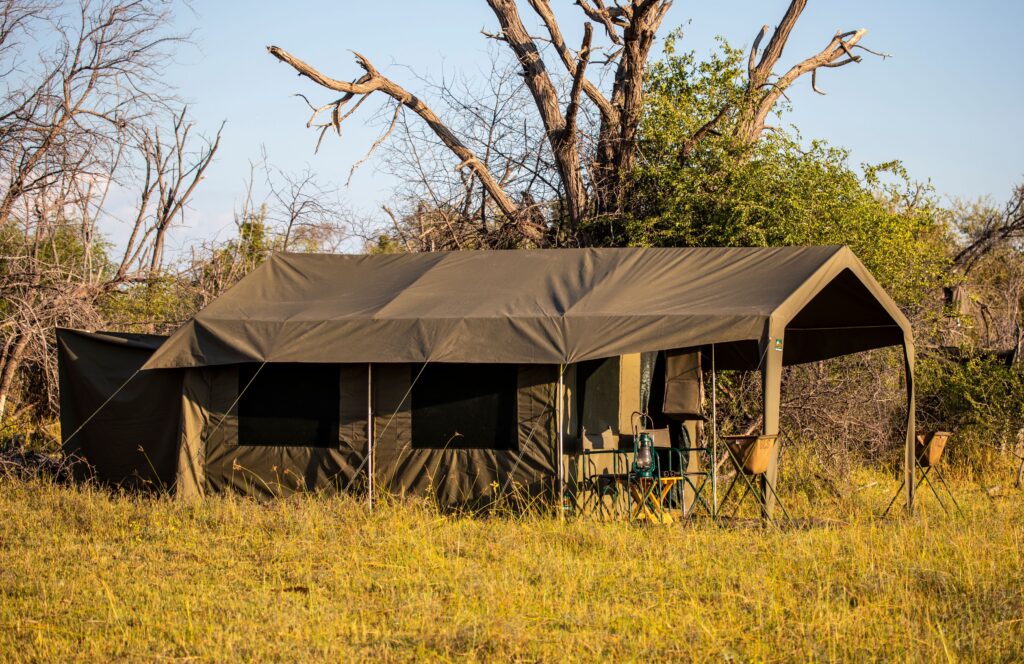 Safari tent pitched beneath trees in the bush